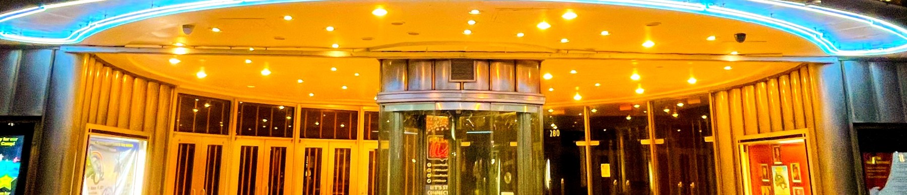 Illuminated Art Deco cinema marquee at dusk